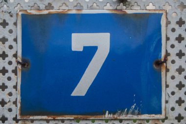 Yıpranmış 7 numaralı sokak adresinin plakası işlemeli eski kare metal.