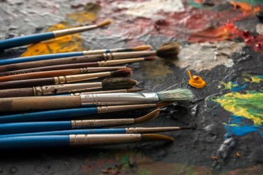 Renkli atrist paletinde farklı boya fırçaları kullanılmış.