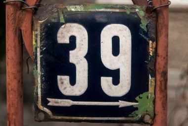 Yıpranmış kare metal plaka numarası 39 olan sokak adresi.