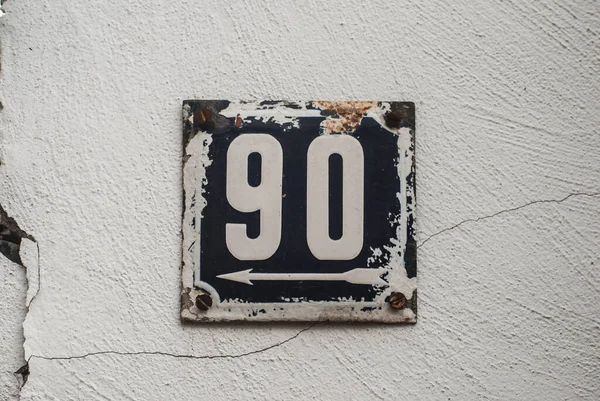 Weathered grunge square metal enamelled plate of number of street address with number 90