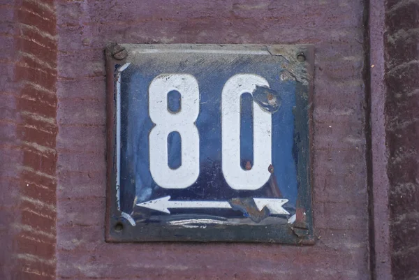 Weathered grunge square metal enamelled plate of number of street address with number 80