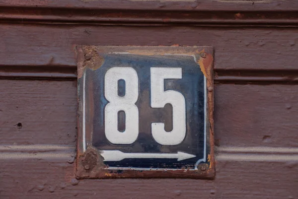 Weathered grunge square metal enamelled plate of number of street address with number 85