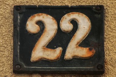 Old retro weathered cast iron plate with number 22 closeup clipart
