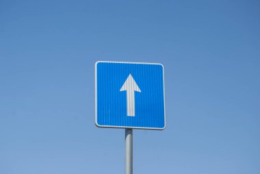 Mavi dikdörtgen tek yönlü trafik işareti mavi gökyüzü arka planında