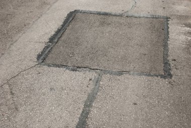 Çatlak asfalt yol yüzeyi ve yakın çekim yaması