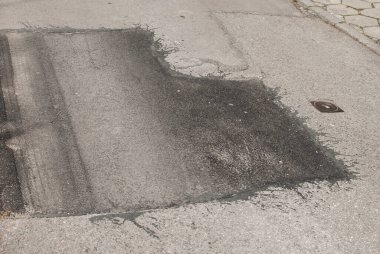 Çatlak asfalt yol yüzeyi ve yakın çekim yaması