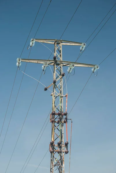 澄んだ青空を背景に高電圧の電柱と送電線 — ストック写真