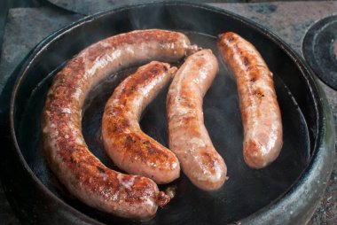 Kızarmış sosisler kırsal fırının dışındaki toprak çömlekte hazırlandı.