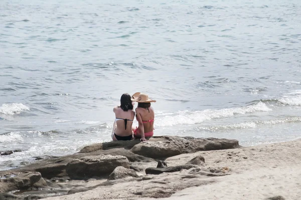 Mädchen sitzen auf Strandfelsen — Stockfoto