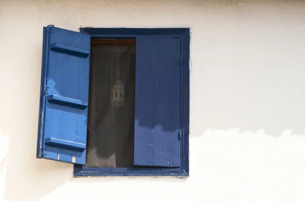 Niebieskie okno na białej ścianie — Zdjęcie stockowe