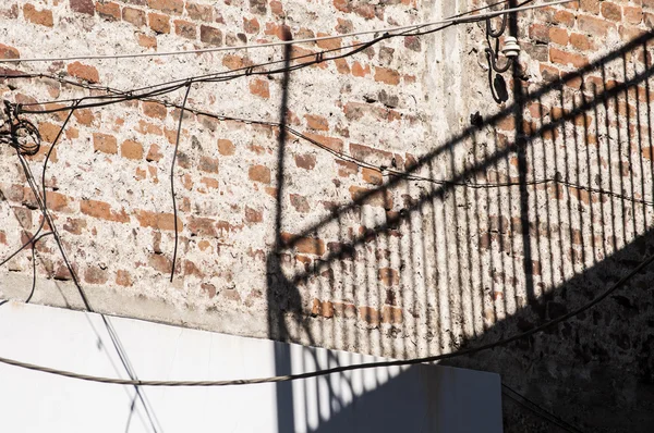 Sombra de valla de metal en el muro de ladrillo —  Fotos de Stock