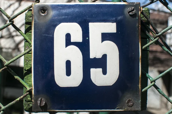 Weathered enameled plate number 65 — Stock Photo, Image