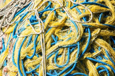 Canlı balık ağları ve şamandıralar bir rıhtıma yığılmış, denize hazır, yakın.