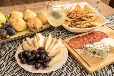 Çeşit çeşit peynir, meyve, şarküteri, patates kızartması ve beyaz şarap. Yemek ve yaşam tarzı teması için mükemmel.