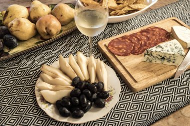 Çeşit çeşit peynir, meyve, şarküteri, patates kızartması ve beyaz şarap. Yemek ve yaşam tarzı teması için mükemmel.