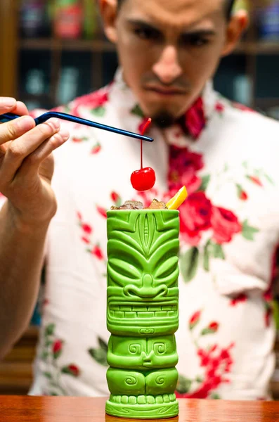 Barman zet een kers op een tiki cocktail. — Stockfoto