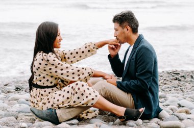 Genç aşık çift, çekici erkek ve kadın sahilde romantik bir buluşmanın tadını çıkarıyorlar.