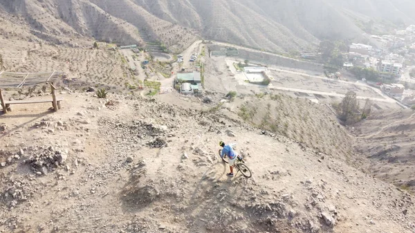 Hombre montando bicicletas de montaña a lo largo del estéril terreno rocoso. —  Fotos de Stock