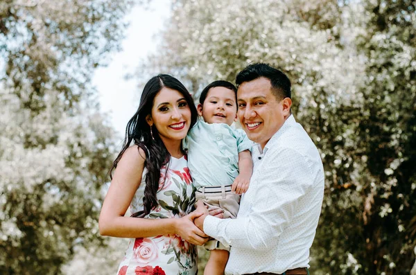 Portret van gelukkige mooie familie van drie wandelen in het park. Moeder, vader en zoontje genieten van vrije tijd in de zomer. — Stockfoto