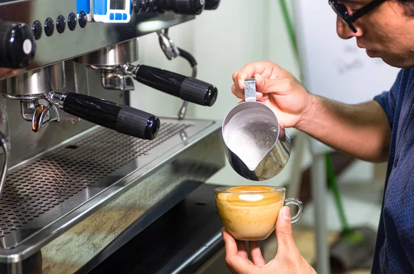 Mano de barista haciendo café con leche o capuchino, vertiendo leche haciendo arte con leche. —  Fotos de Stock