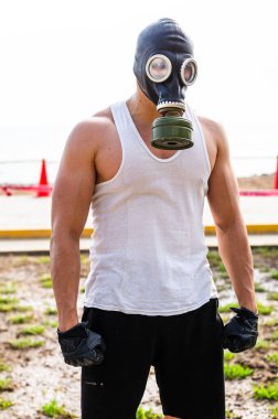 Gaz maskeli kaslı bir adam..