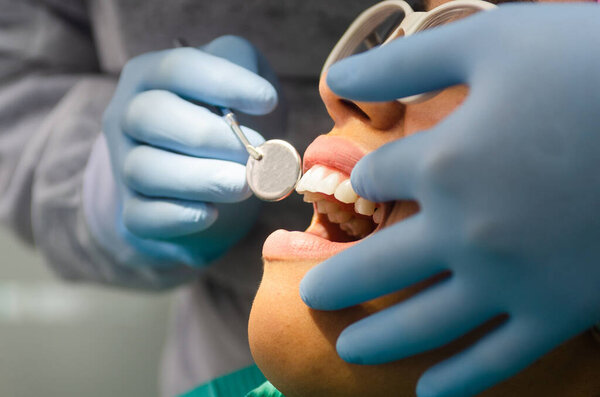 Young female patient takes a dental attendance in the dentists office.
