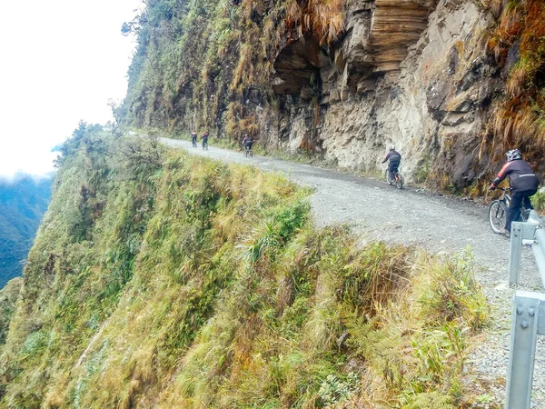 Montanha motociclistas montando o famoso downhill trilha Estrada da morte na Bolívia. — Fotografia de Stock