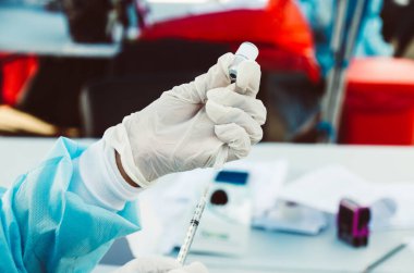 Şırınga, elinde tıbbi enjeksiyon, avuç içi ya da parmak. İğneli tıbbi plastik aşı ekipmanı. Hemşire ya da doktor.