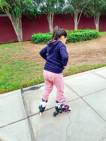 Niña caucásica de 8 años montando patines sobre ruedas en la carretera en el parque. Estilo de vida infantil saludable. — Foto de Stock