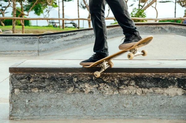 Deskorolkarz robi krzywy trik szlifowania na ławce w skateparku. — Zdjęcie stockowe