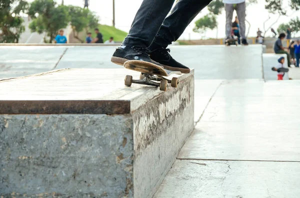 Skater robi sztuczkę w skateparku o nazwie grind o 50 - 50. — Zdjęcie stockowe