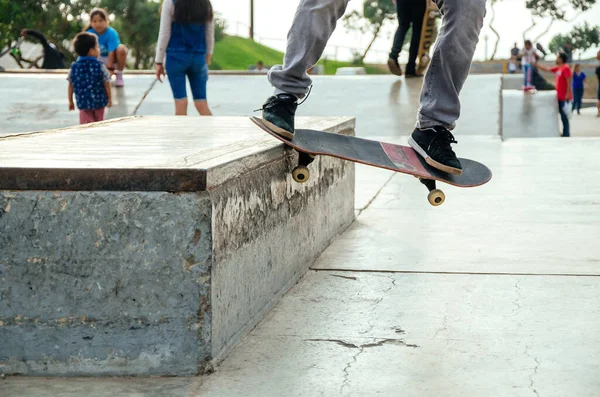 Skateboarder está fazendo um truque de moagem torto em um banco no skatepark. — Fotografia de Stock