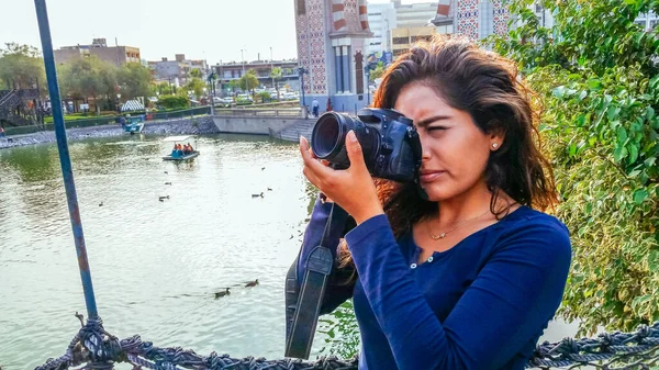 Vacker kvinna är en professionell fotograf med en DSLR kamera i parken. — Stockfoto
