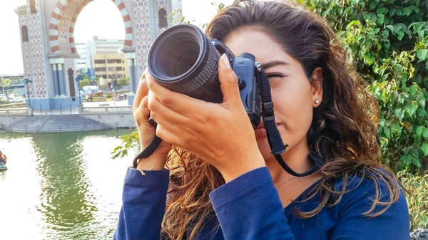 Mulher bonita é uma fotógrafa profissional com uma câmera DSLR no parque. — Fotografia de Stock