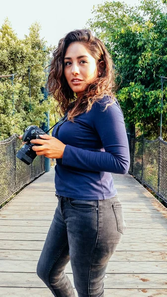 Hermosa mujer es un fotógrafo profesional con una cámara réflex digital en el parque. — Foto de Stock