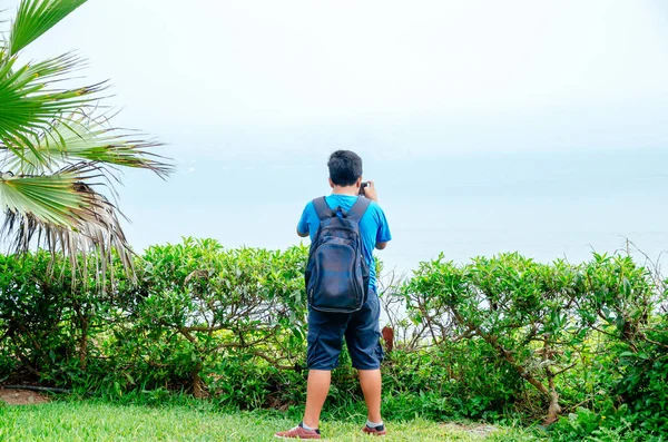 Bambino che scatta foto con il suo smartphone al mare. — Foto Stock