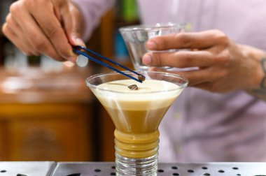 Barmen İrlanda kahvesi adında alkollü bir içecek hazırlıyor..