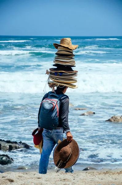 Seller sapkák sok kalap a fején, a strandon Lima - Peru. — Stock Fotó