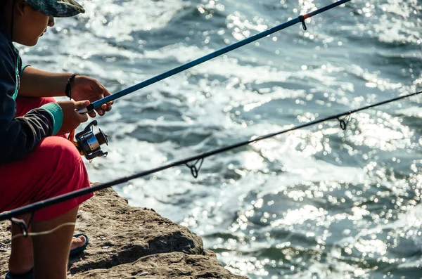 Pescatore seduto con una canna da pesca in mare, pesca. — Foto Stock