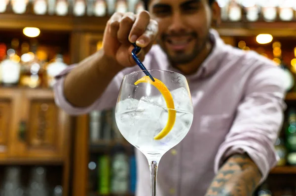 Barman zdobí sklenici čerstvého alkoholického koktejlu na pultu baru, detailní záběr. — Stock fotografie