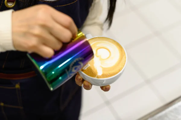 Manos de barista haciendo café con leche o capuchino vertiendo leche, haciendo arte de café con leche. —  Fotos de Stock