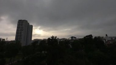 Şehir silueti rengarenk günbatımı ve canlı şehir ışıklarıyla günden geceye değişiyor.