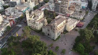 Drone modern binaların arasında klasik bir katedralle canlı bir şehir meydanı yakalıyor.