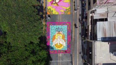 Şehir sokaklarında Paskalyayı kutlayan canlı bir çiçekli halının yukarıdan çekimleri.