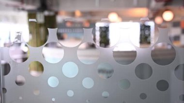 Bir ofis ortamında dairesel buzlu desenler içeren şık bir cam bölmenin yakın çekimi