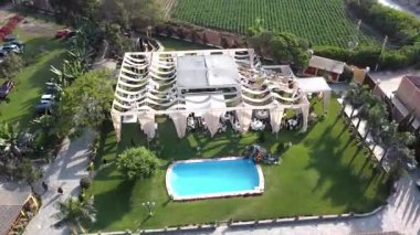 Yeşilliklerle dolu bir havuzun kenarında güzel düzenlenmiş bir düğün töreninin robot resmi.