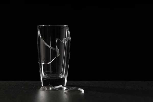 broken empty glass on a ceramic surface on a dark background. problem concept