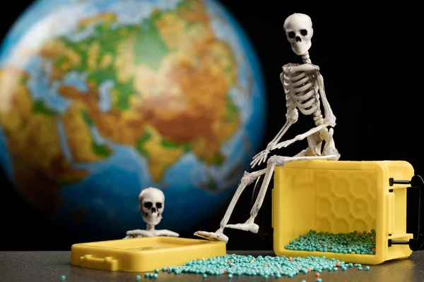 Het Skelet Zit Een Gele Doos Waaruit Kralen Uitstromen Achtergrond — Stockfoto