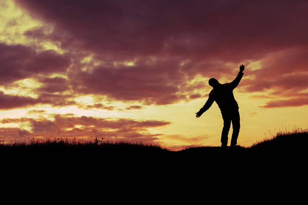 silhouette of a man who does not stand steadily and staggers against the sunset. stress and problem concept