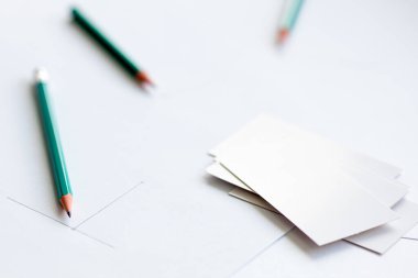 Beyaz kağıt üzerinde beyaz kartvizitler, yan yana iki kalem ve kurşun kalemle çizilen diyagramın başlangıcı. Çalışmanın başlangıcı